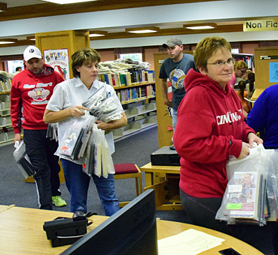 Volunteers carry children's materials from the basement upstairs. Dave Mosier/Van Wert independent