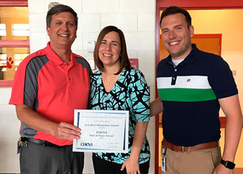 Van Wert Elementary School Principal Kevin Gehres (left) and Assistant Principal Justin Krogman (right) receive the Hall of Fame School certificate from Dr. Rebecca Hornberger from Ohio Association of Elementary School Administrators at a staff luncheon held to celebrate the award. (photo submitted)